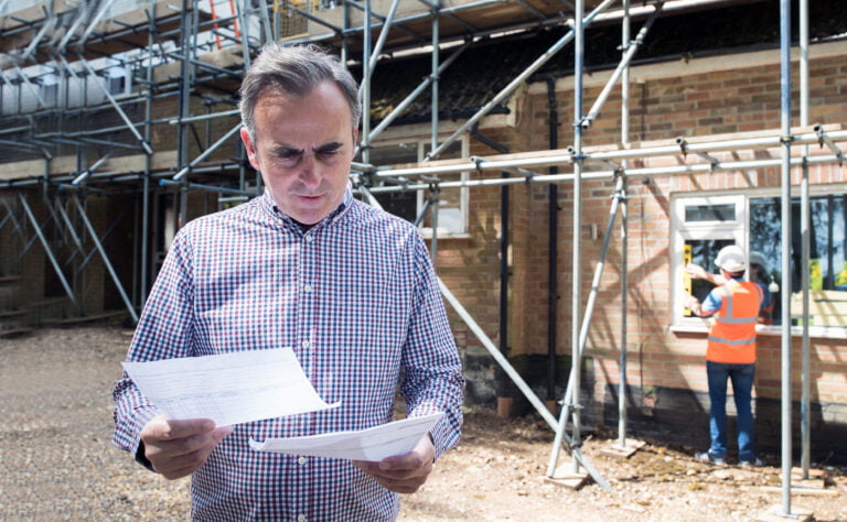 unhappy homeowner building a new home looking at building paperwork